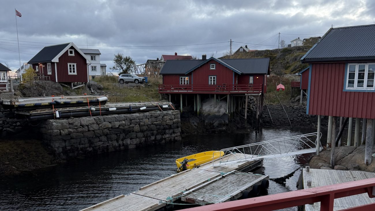 Røde rorbuer på påler ved en liten havn